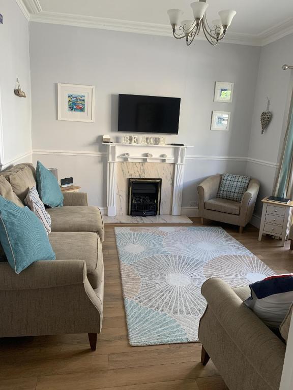 a living room with two couches and a fireplace at Perfect base for 8, pets allowed in Tenby