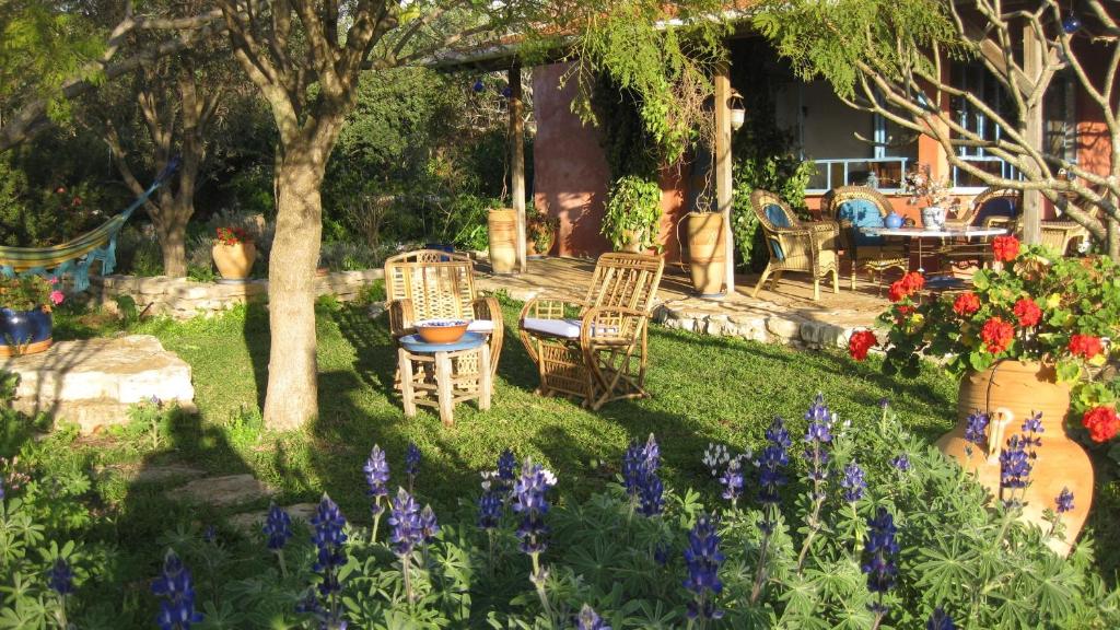 - un jardin avec des chaises, une table et des fleurs dans l'établissement Villa Adama, à Clil