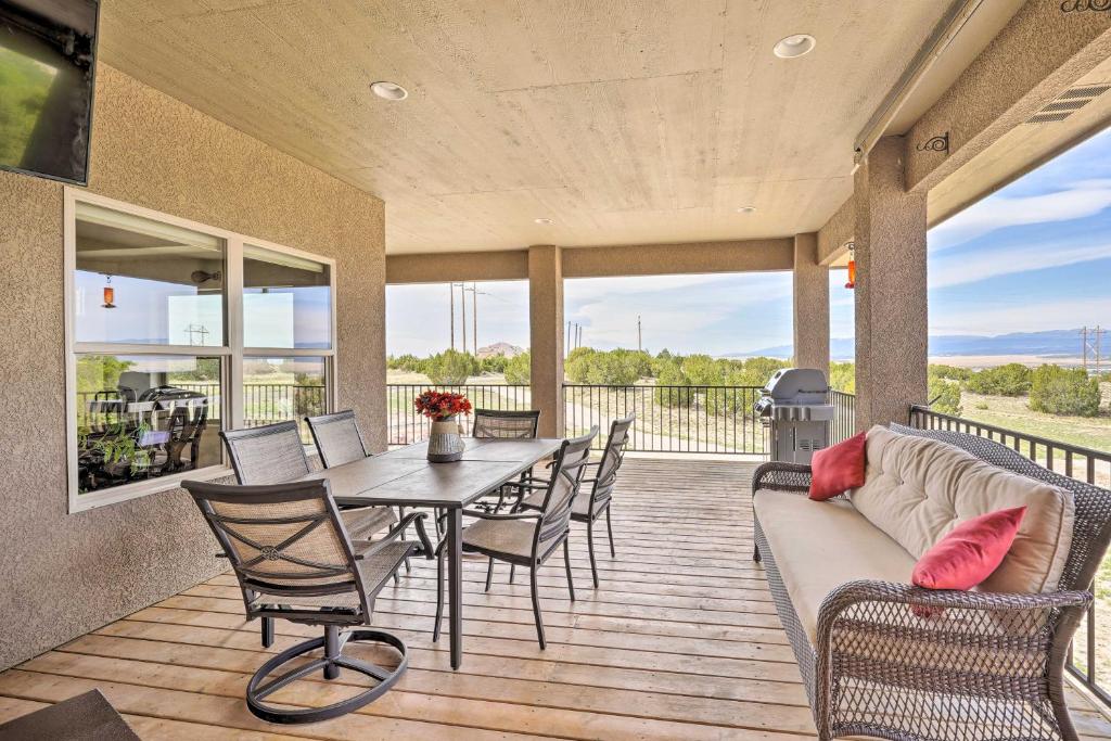 - une terrasse couverte avec un canapé, une table et des chaises dans l'établissement Pueblo West Home - Full Deck and Near Reservoir, à Pueblo