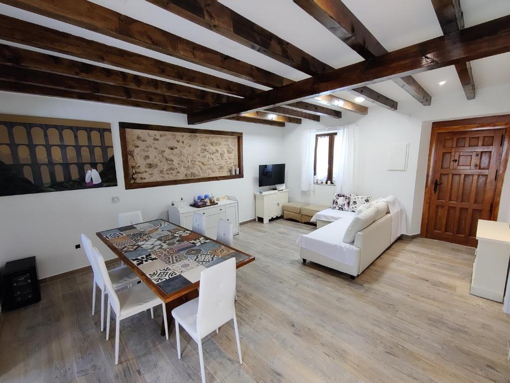 Navas de RíofríoにあるCasa Rural Las Cigüeñas de Las Navillasのリビングルーム(テーブル、白い椅子付)