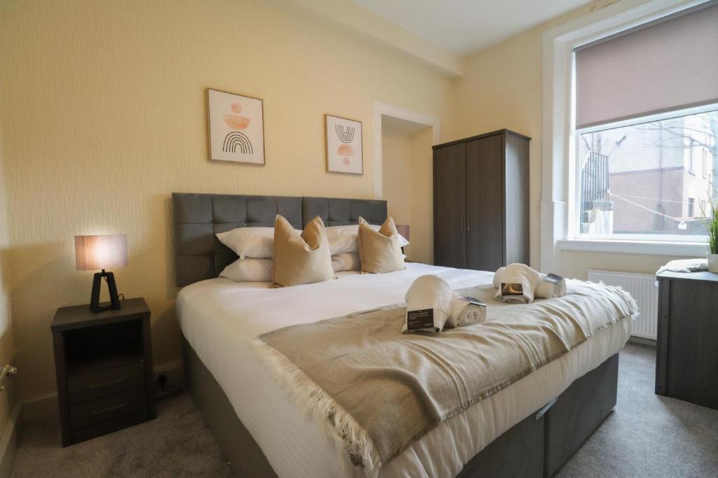 una camera da letto con un grande letto con una grande finestra di Cosy Ardrossan Apartment ad Ardrossan