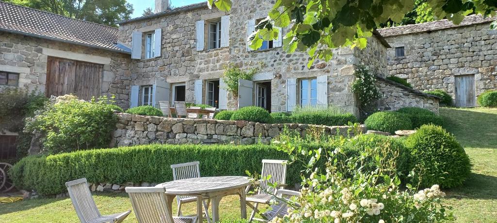 a table and chairs in front of a stone building at Bérard in Intres