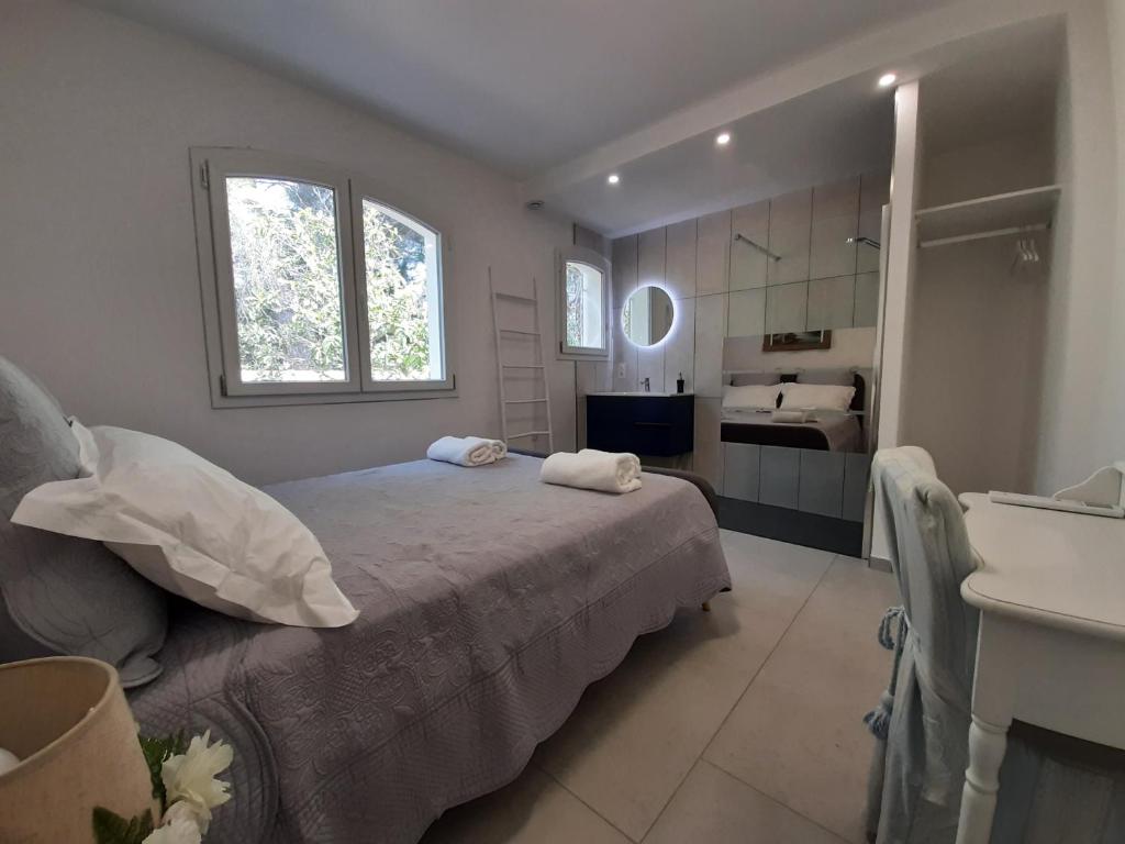 a bedroom with a bed and a bathroom with a sink at VILLA RASOA chambre LIBELLULE in Cap d'Agde