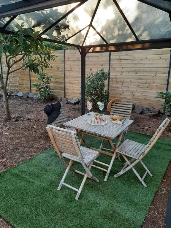 a picnic table and two chairs under a greenhouse at VILLA RASOA chambre LIBELLULE in Cap d&#39;Agde