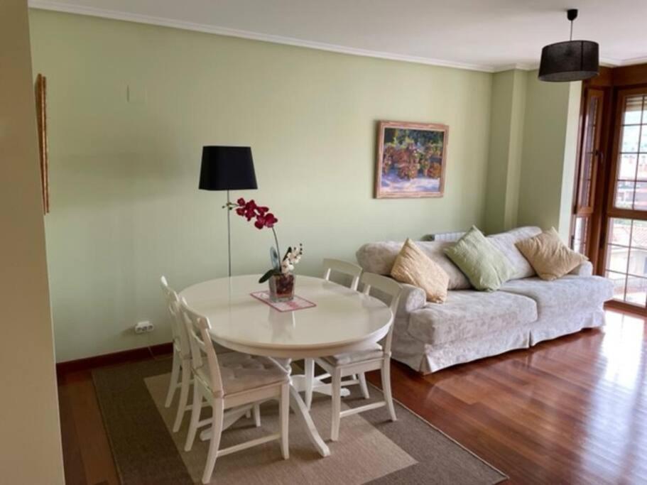 sala de estar con mesa y sofá en Bonito apartamento con piscina en Ribas