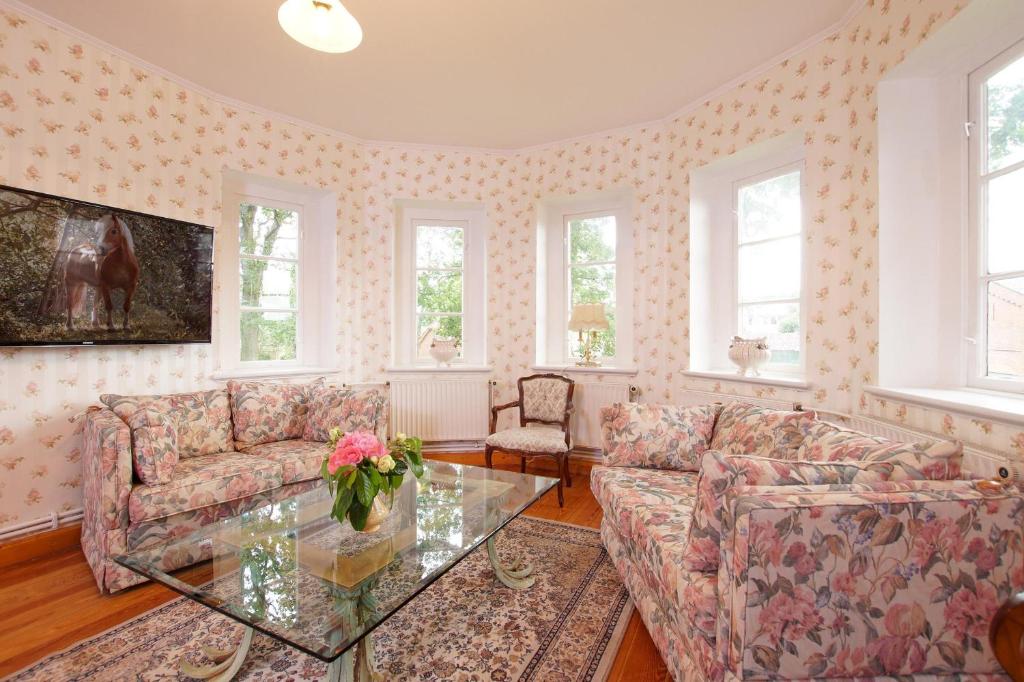 a living room with two couches and a glass table at Reiterhof Behrens Wohnung Sachau in Merkendorf