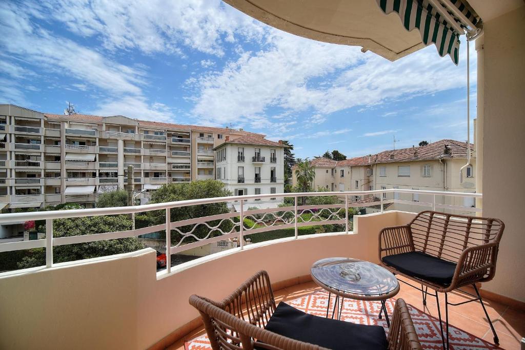 un balcon avec deux chaises et une table sur un balcon dans l'établissement IMMOGROOM - Spacieux 3 pièces - Garage - Terrasse - Climatisation, à Cannes