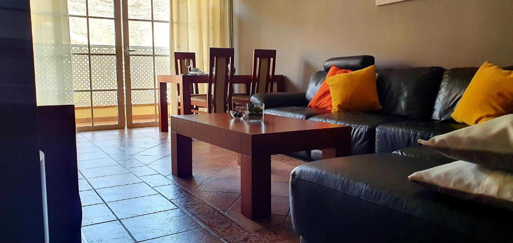een woonkamer met een bank en een tafel bij Apartamento Carmen in Morro del Jable
