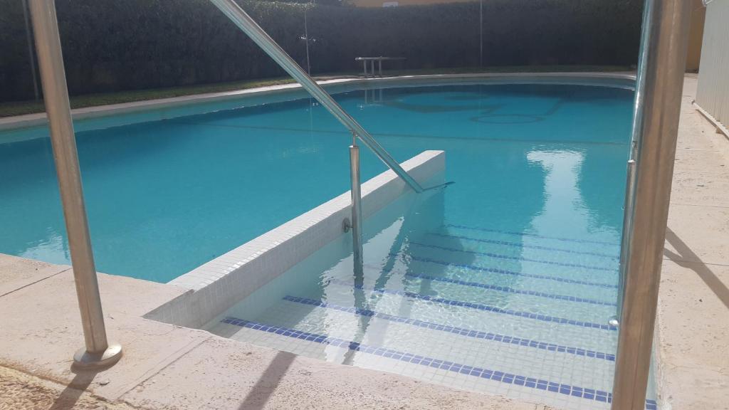 - une piscine bleue avec des escaliers dans un bâtiment dans l'établissement Piso relax Piscina y playa Aguadulce, à Aguadulce