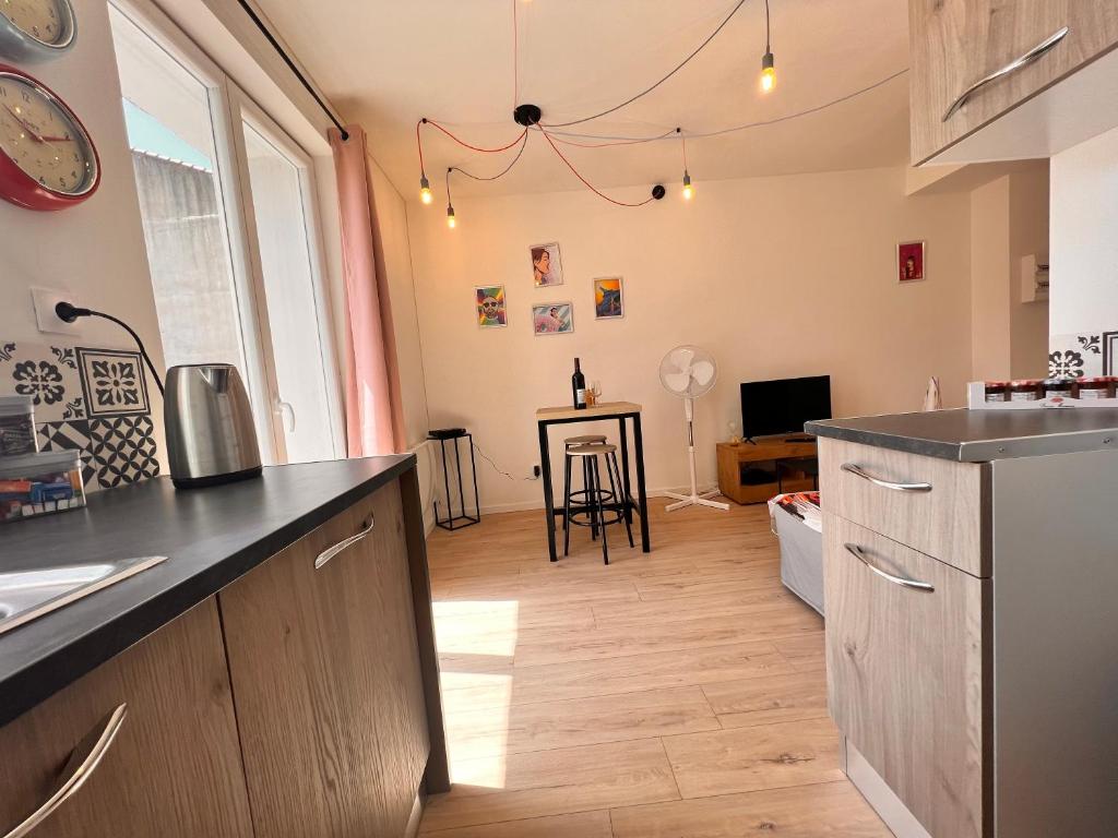 a kitchen with a counter and a living room at 9mins de Lamalou-les-Bains 30mins Avène 40m² in Bédarieux