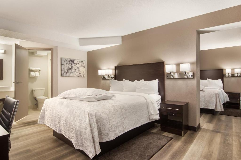 Habitación de hotel con 2 camas y baño en Red Roof Inn PLUS & Suites Erie, en Erie