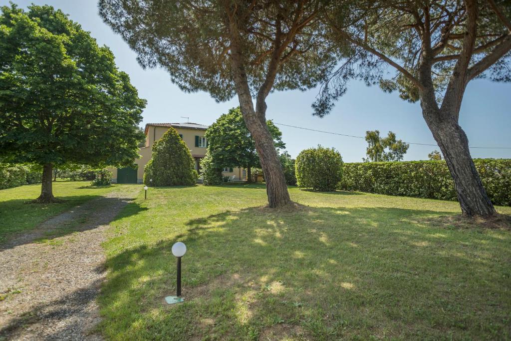 un cortile con due alberi e una casa di Podere Belvedere Livorno a Livorno