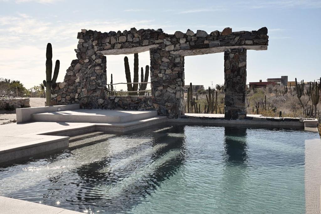 un bâtiment en pierre avec une piscine dans l'établissement Desierto Azul, à Todos Santos