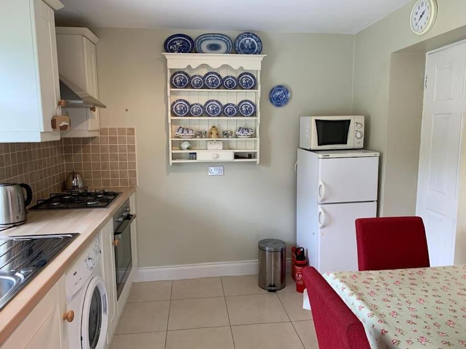 a kitchen with a white refrigerator and a microwave at Butler's Cottage, Letterkenny in Letterkenny