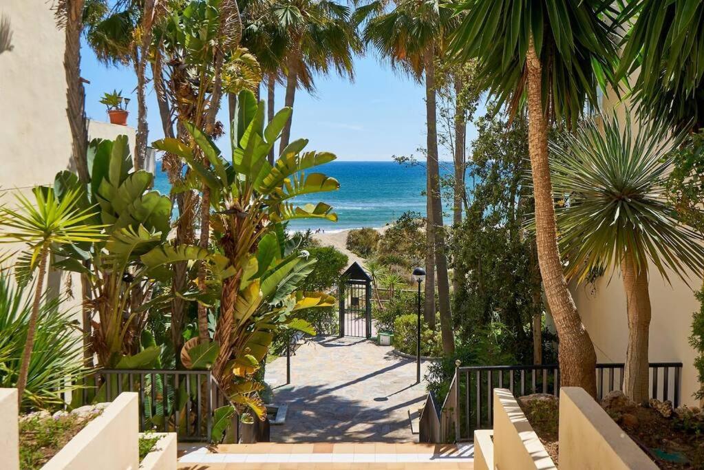 - Vistas a la playa desde un complejo con palmeras en OleHolidays 405 Loft Romana Playa junto al mar, en Marbella