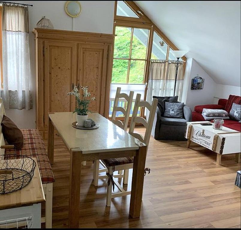 uma sala de estar com uma mesa e um sofá em Ferienland Sonnenwald Fewo 46 und Studio 50 in Schöfweg Bayerischer Wald em Schöfweg