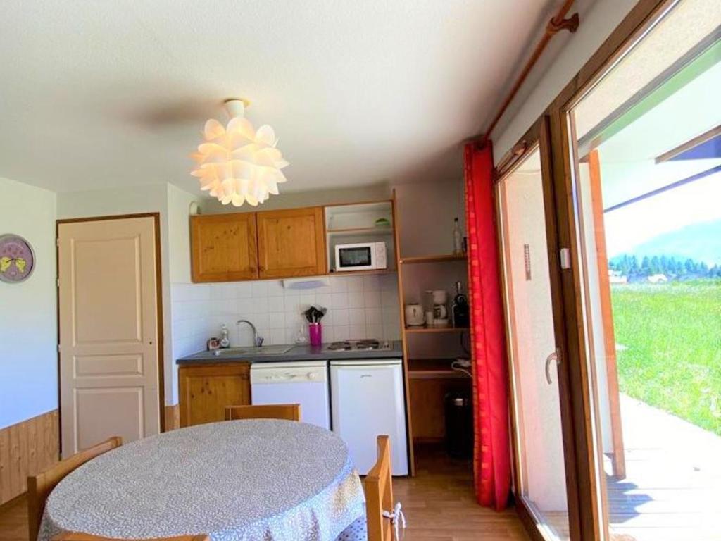une cuisine avec une table et une cuisine avec une fenêtre dans l'établissement Appartement rénové 6 pers, terrasse, parking, local ski - FR-1-504-150, à Saint-Étienne-en-Dévoluy