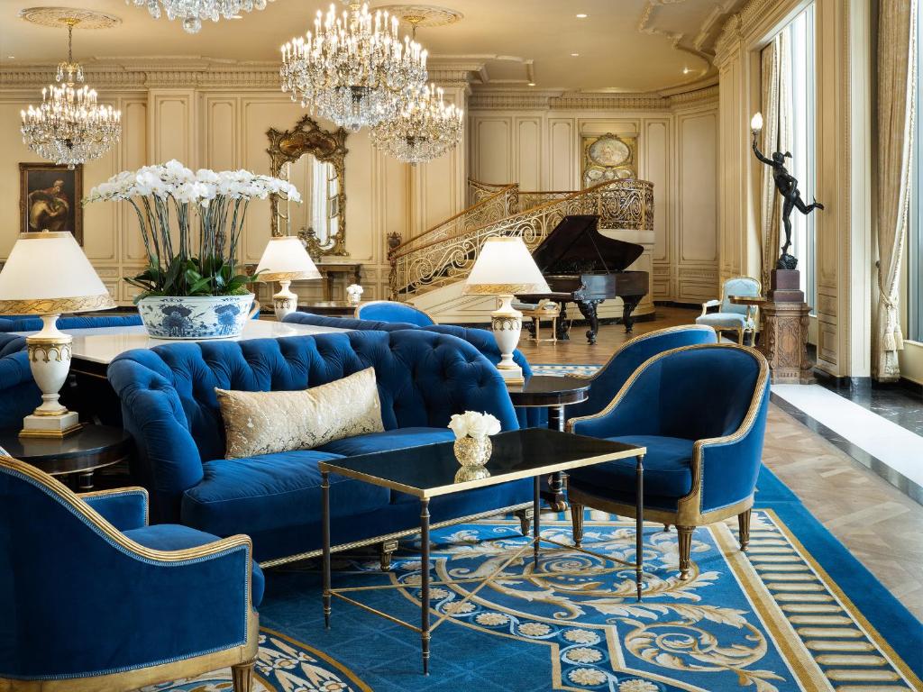 a living room with a blue couch and chairs and a piano at The Westgate Hotel in San Diego