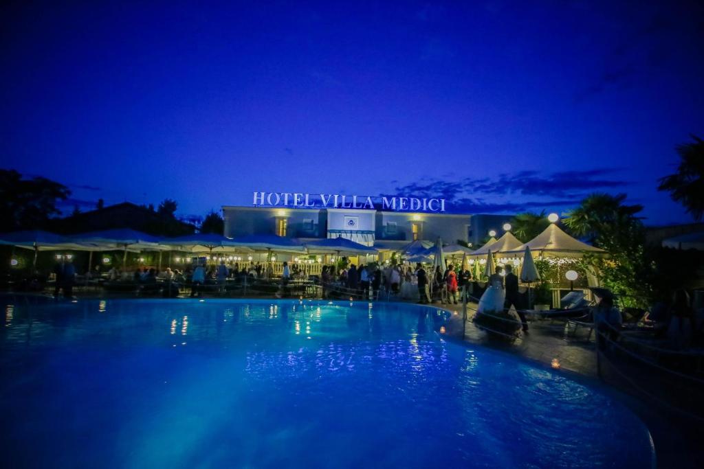 a large swimming pool in front of a hotel at night at Hotel Villa Medici in Rocca San Giovanni