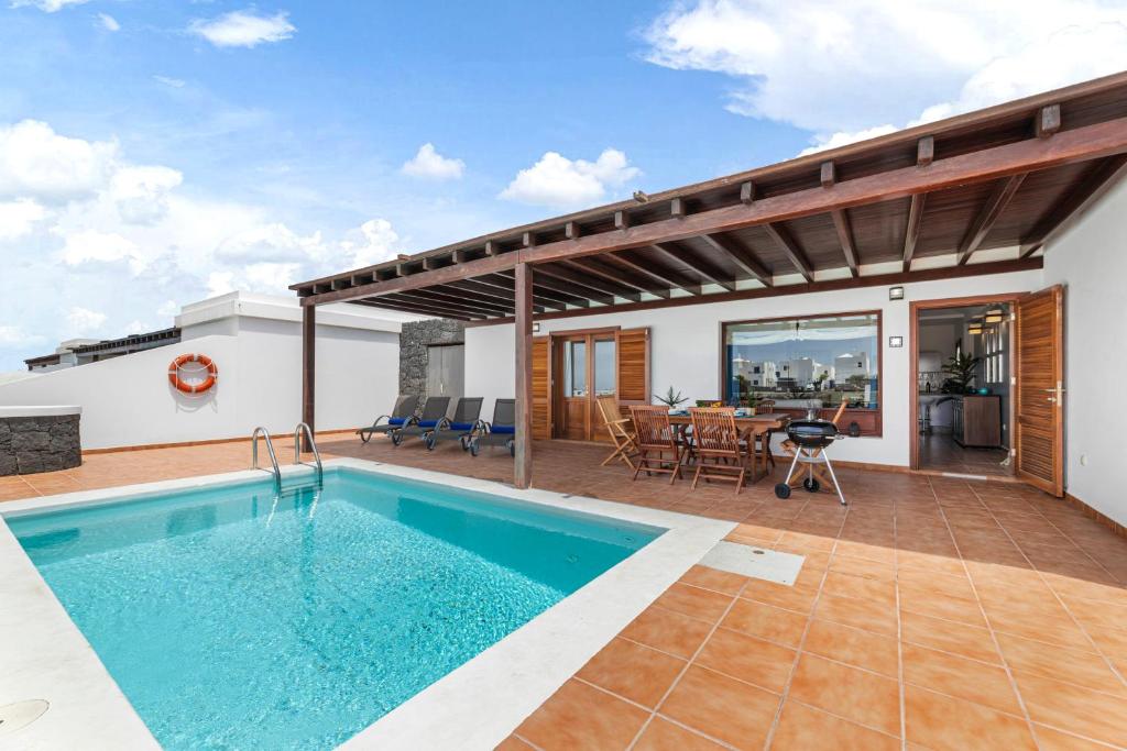a villa with a swimming pool and a patio at Lanzarote Villa 3 Islas in Playa Blanca