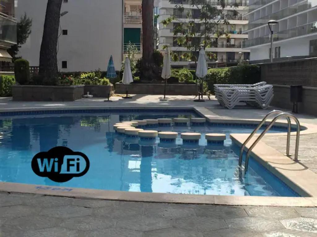 una piscina con un logotipo de hotel en Apartamento centrico y con piscina a 5 min. playa en Salou