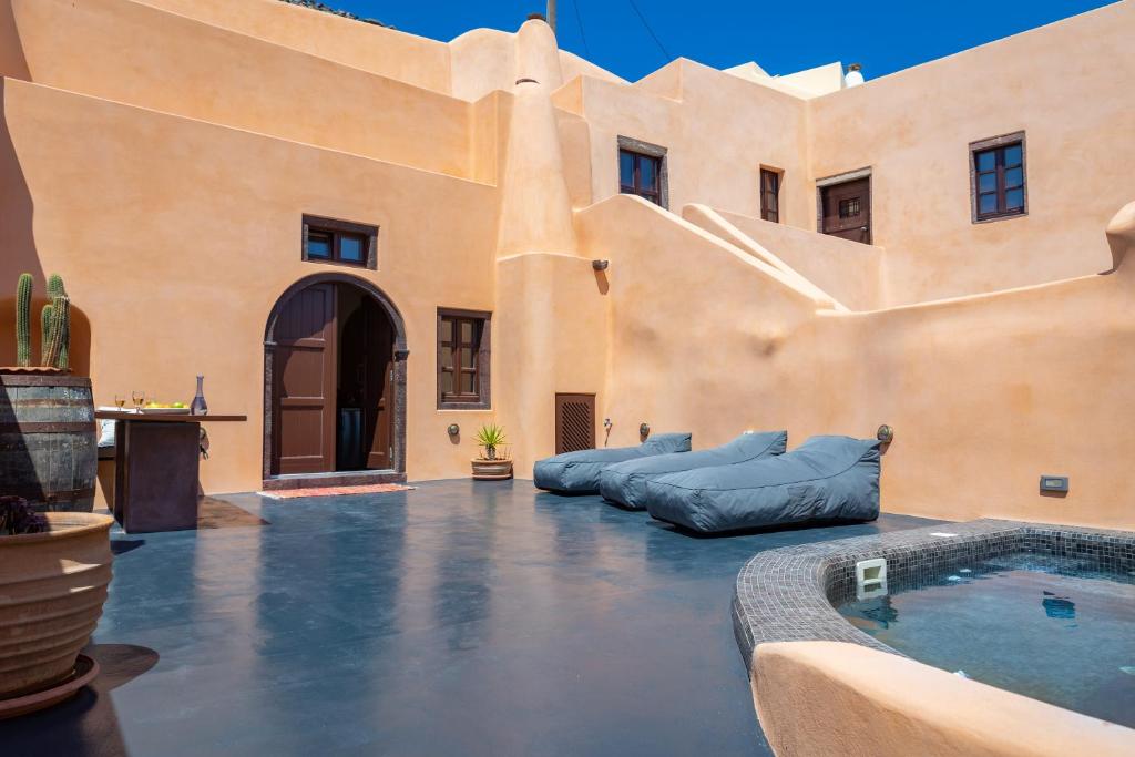 an outdoor patio with a swimming pool in a house at Azalea Houses in Oia