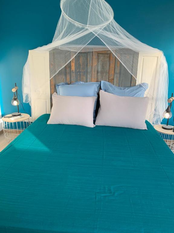 a bedroom with a blue bed with a canopy at Casa Rosalinda in Figari