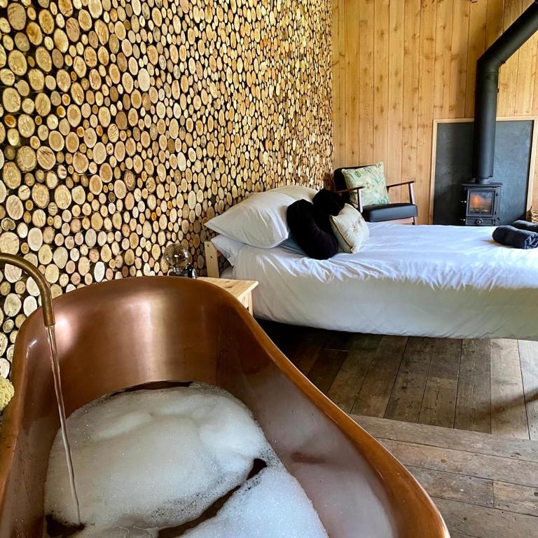 a bedroom with a tub filled with snow and a bed at Bee Bole Cabin in Monmouth