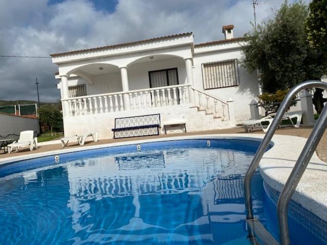 a large blue swimming pool in front of a house at LES ILLES PEÑISCOLA in Peñíscola