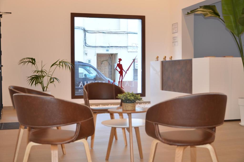 d'une salle à manger avec des chaises, une table et une fenêtre. dans l'établissement El SUEÑO DE LA MANCHA, à Mota del Cuervo