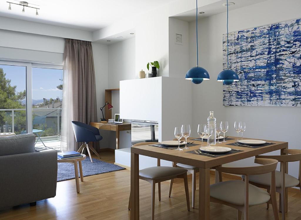 een eetkamer met een houten tafel en stoelen bij Scale Suites in Athene