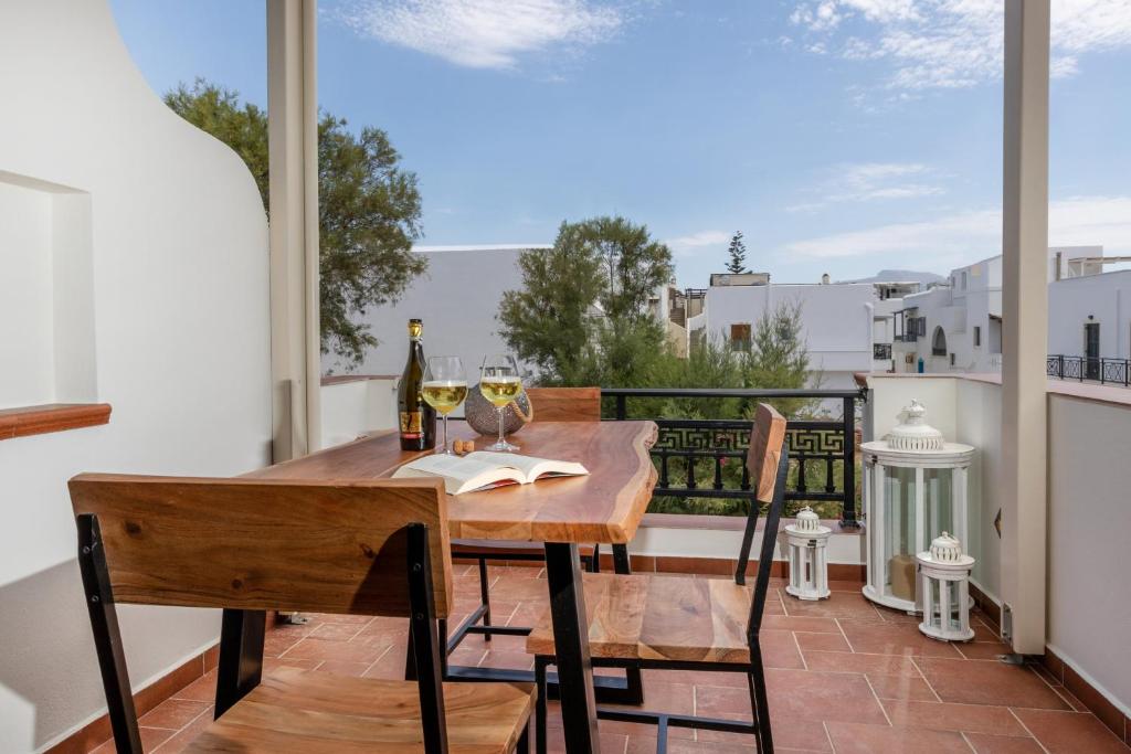 a table and chairs on a balcony with a bottle of wine at Kallisti Studios in Naxos Chora