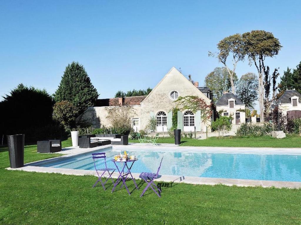 une maison avec une piscine, une table et des chaises dans l'établissement Le Clos des Aubrys, à Châteauroux