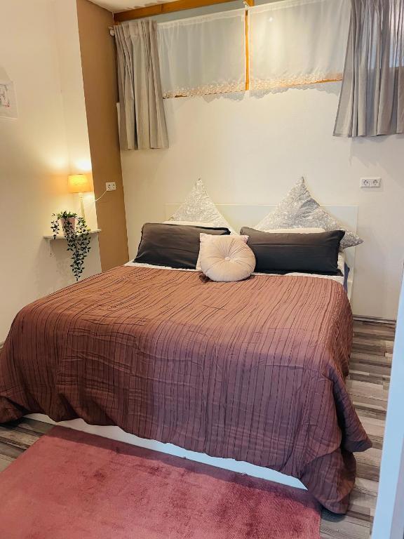 a bedroom with a large bed with a brown comforter at Ferienwohnung Marina an der Romantischen Straße in Weikersheim