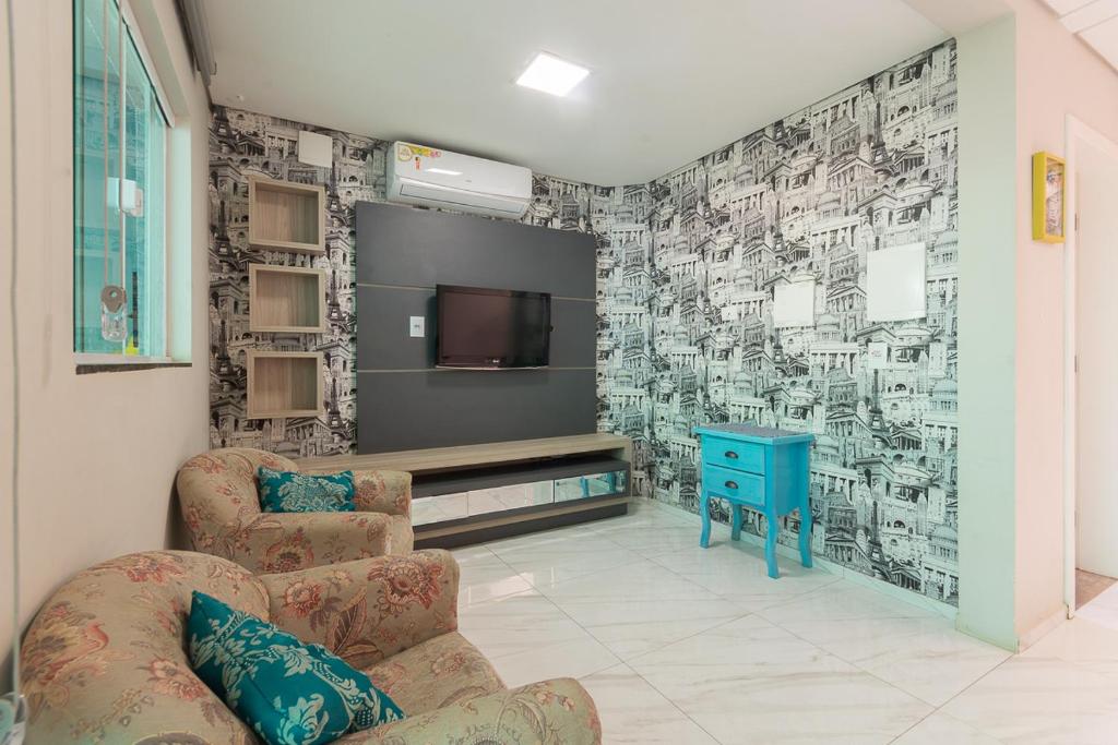 uma sala de estar com uma televisão e um sofá em Sobrado Smart - Melhor Localização de Foz do Iguaçu em Foz do Iguaçu