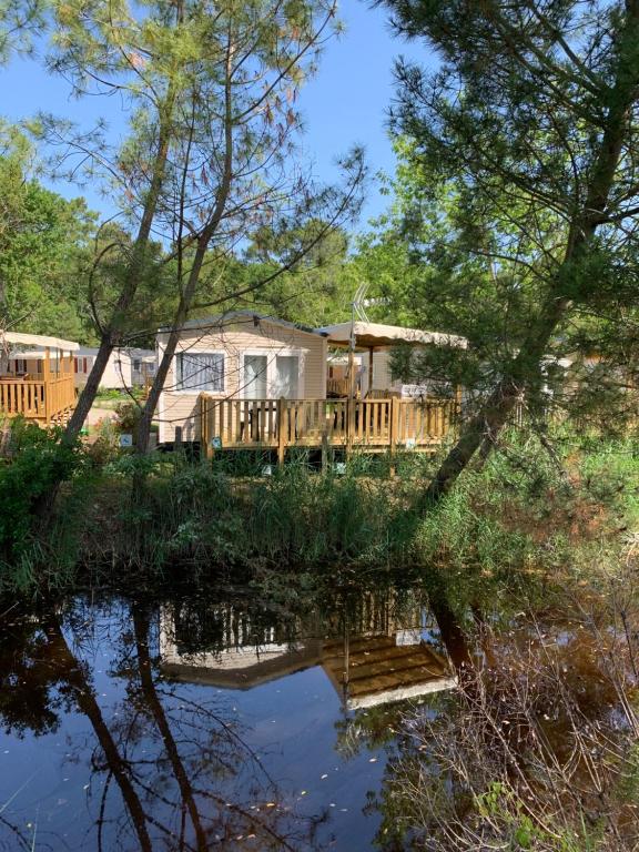 dom z tarasem i stawem w obiekcie Envie d un break de paysages sauvages et de nature ce mobile home neuf tout confort climatise idealement situe au bord de l eau dans un camping 4 etoiles vous attend pour un week end quelques jours ou des vacances en famille w mieście Cap-Ferret