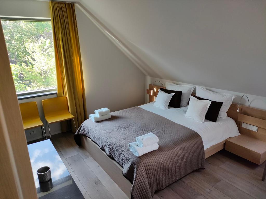 a bedroom with a bed with two towels on it at Loft - Dolny Sopot by OneApartments in Sopot
