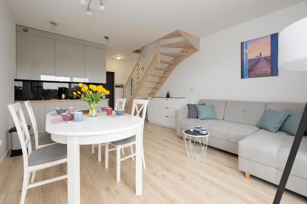 sala de estar con mesa blanca y sofá blanco en Dwupoziomowy Apartament z Parkingiem - Taras i Balkon - 3 Sypialnie by Renters, en Rewal