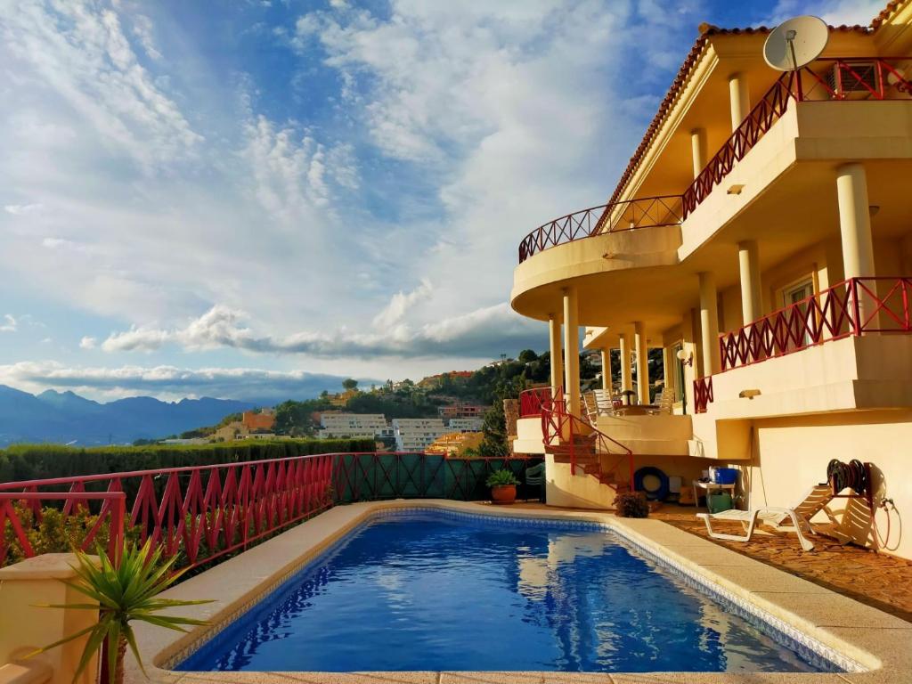 a swimming pool in front of a house at Spacious villa in Altea Hills in Altea