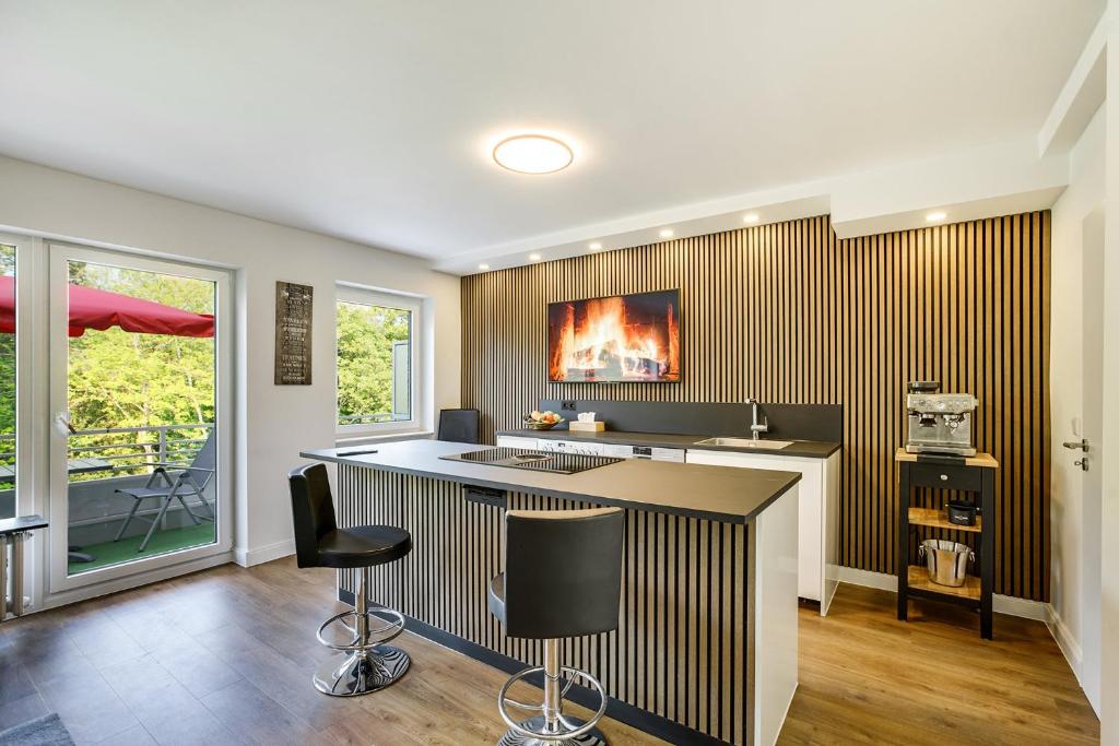 a kitchen with a bar with two stools in it at George Apartment in Düsseldorf