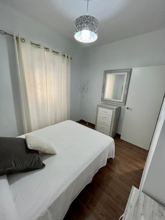 a bedroom with a large white bed and a window at APARTAMENTO TARIFA CENTRO in Tarifa