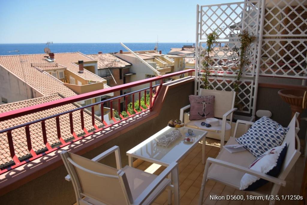 d'un balcon avec une table et des chaises et une vue. dans l'établissement Le Note del Mare appartamento vista mare, à Roccalumera