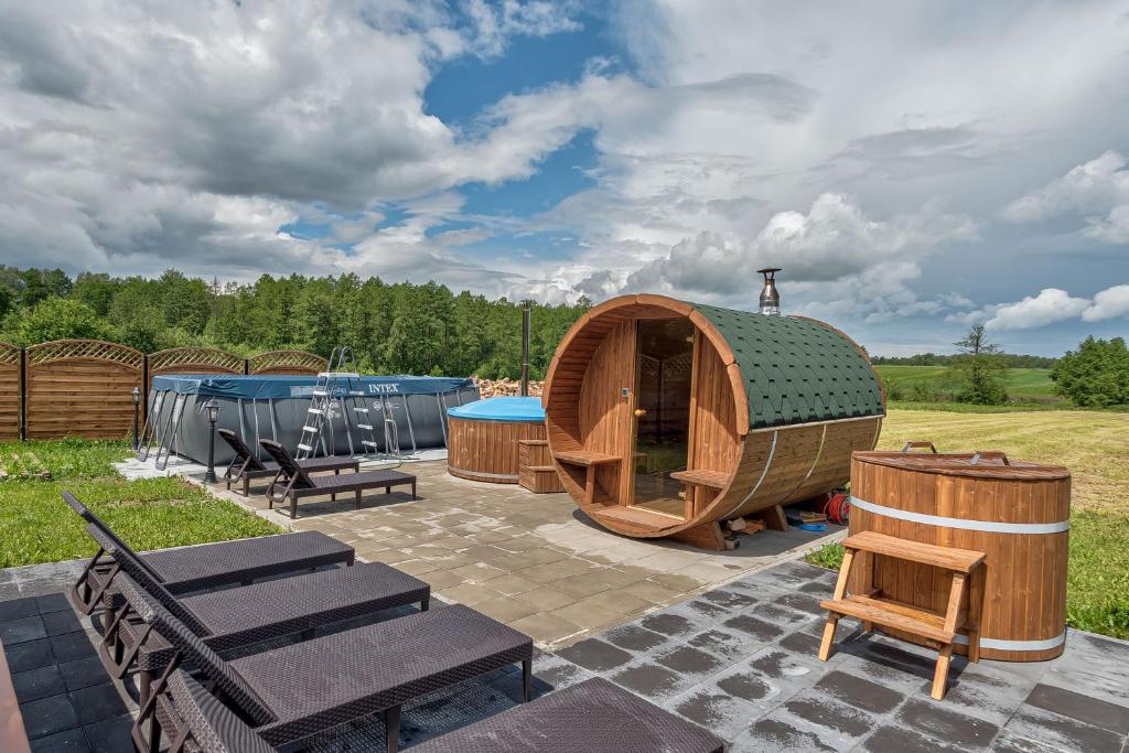 a yurt with a pool and a table and benches at Brzozowy Zakątek-Brzozowa Bania in Tykocin