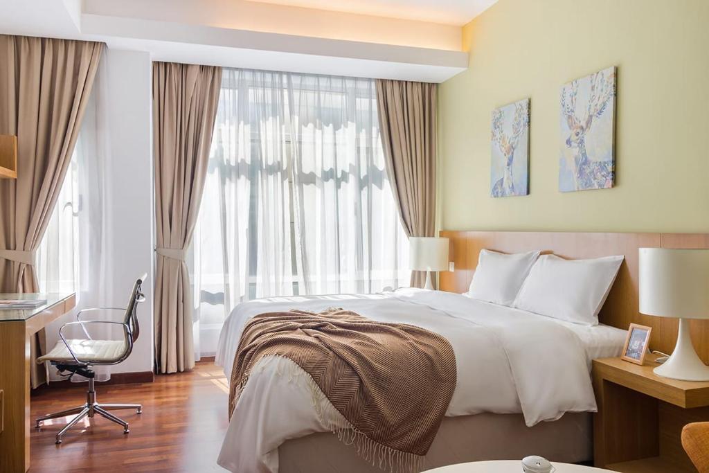 um quarto de hotel com uma cama grande e uma janela em Exclusive Design Studio with Bathtub l Cormar em Kuala Lumpur