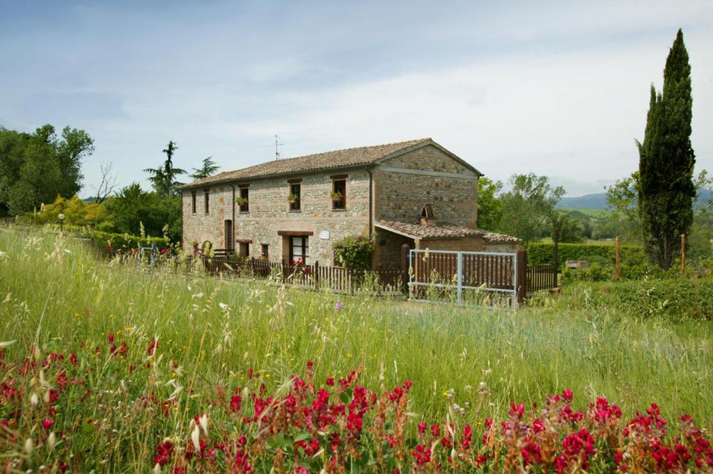 an old stone house in a field of flowers at Casina Centeno in Proceno