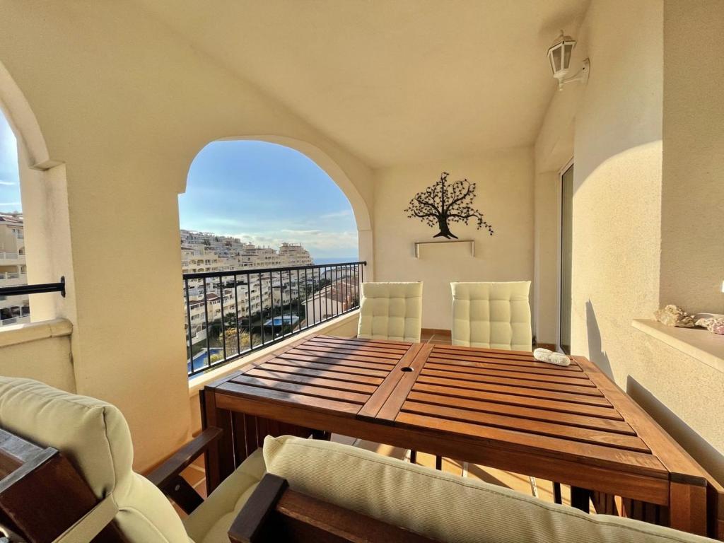 d'un balcon avec une table et des chaises en bois ainsi qu'une fenêtre. dans l'établissement Casa Luna Golf Beach Torrequebrada Parking FREE, à Benalmádena