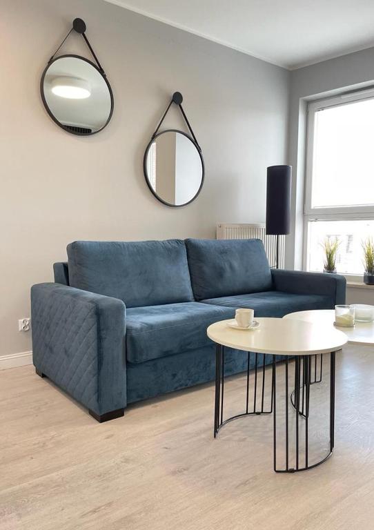 a living room with a blue couch and a table at Apartament Bastion Wałowa in Gdańsk