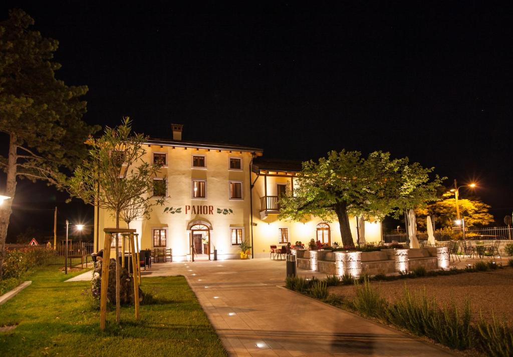 een gebouw 's nachts met een stoep ervoor bij Hotel & Restaurant Pahor in Doberdò del Lago