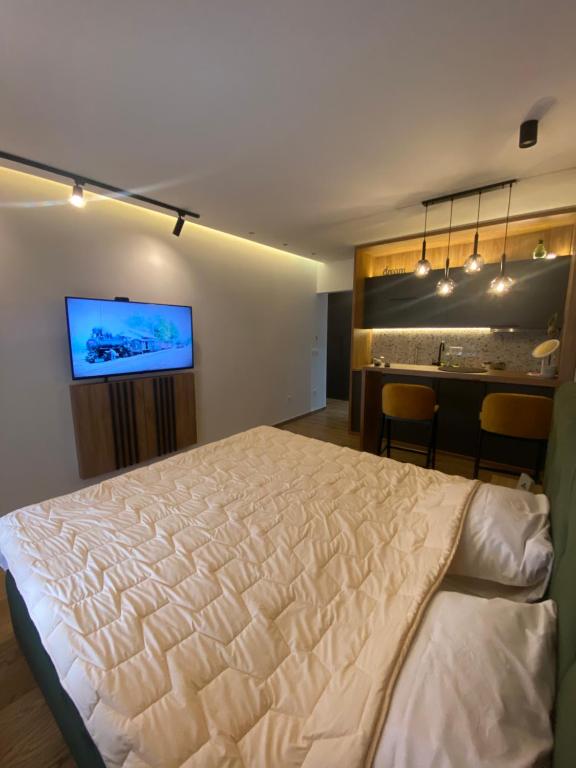 Un dormitorio con una cama grande y un bar en Gomax apartman 4 en Zlatibor