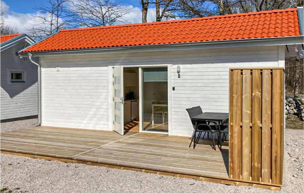 a small white shed with a table on a wooden deck at Beautiful Home In Hassl With Wifi in Hasslö